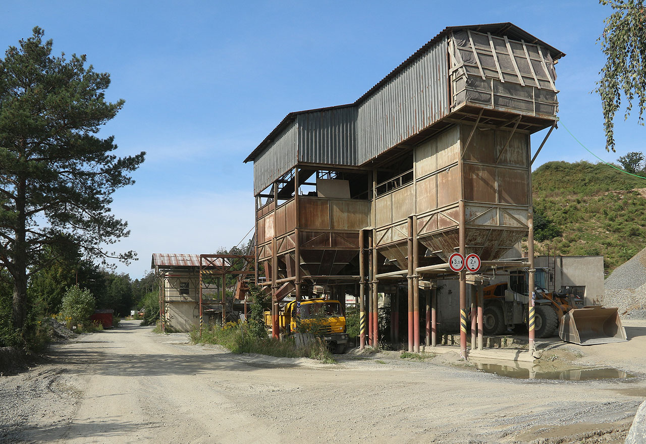 Zásobníky štěrku v lomu, ke kterému, ač leží v nejtěsnější možné blízkosti dráhy, jsem nikdy nedohledal, že by měl vlečku.