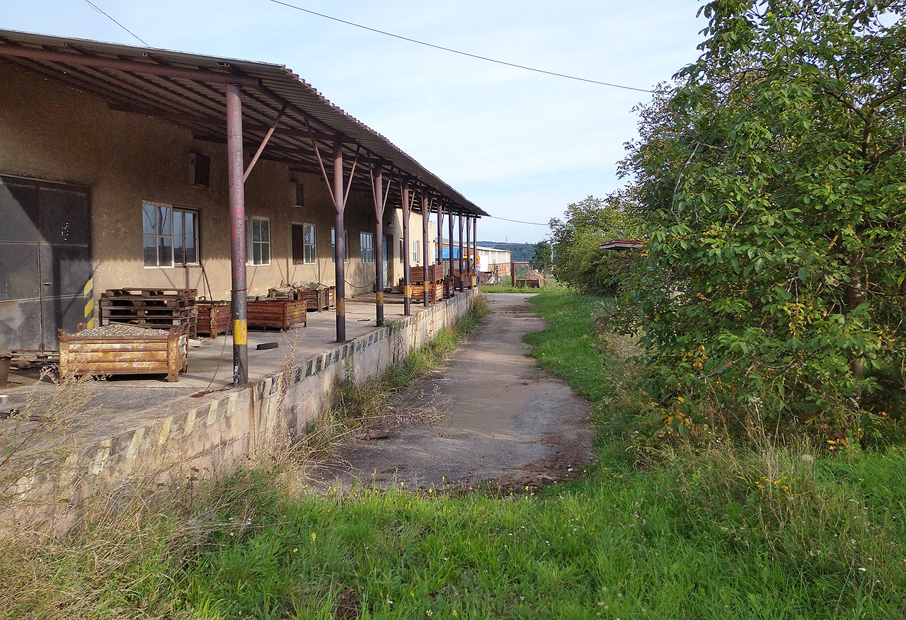 Zachovalá nákladová rampa na zrušené vlečce při Družstevní ulici. Tudy vedla kdysi odbočná dráha. Dnes má v areálu pneuservis pan Libor Závodník.