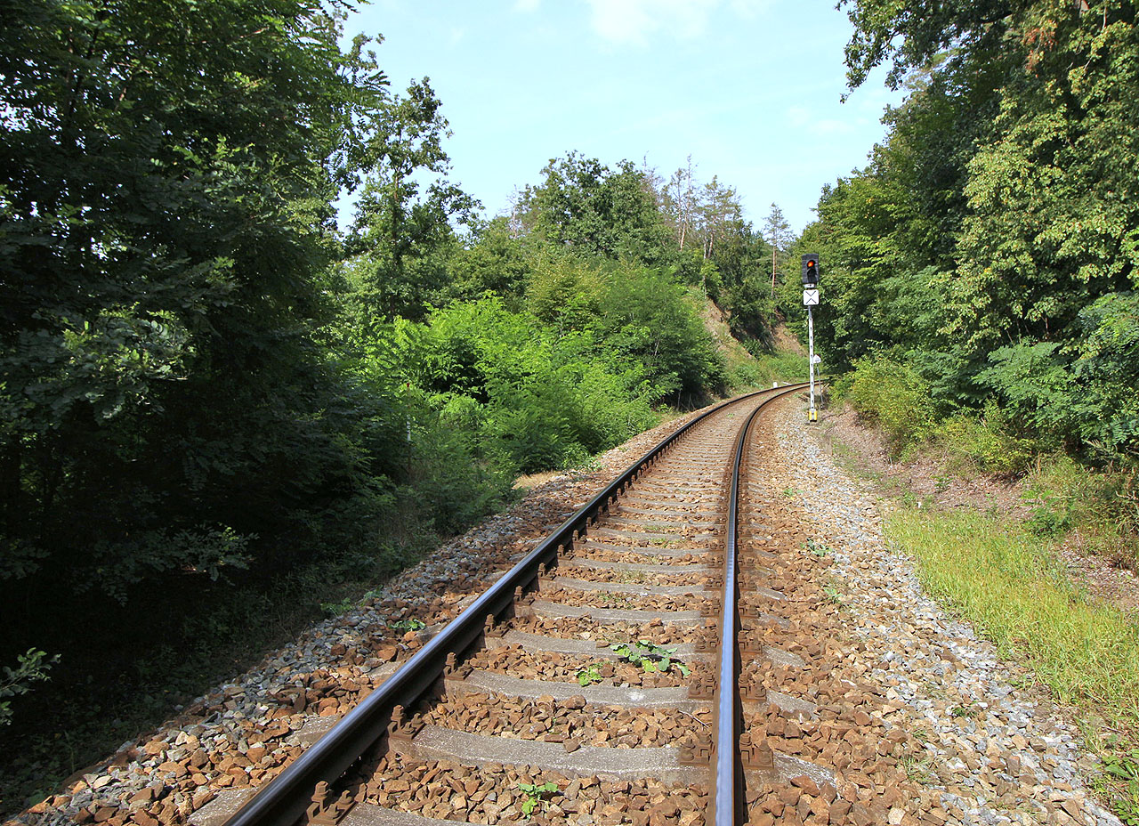 Dalším železničně zajímavým místěm je nedokončený kolejový trojúhelník una západním konci Střelic. Kdysi se tu plánovala spojka od <a href="/Tema/Jihlava (žst)">Jihlavy</a> na <a href="/Tema/Moravské Bránice (žst)">Moravské Bránice</a>, aby mohly vlaky s ohlím jezdit z dolů u Zastávky přímo do <a href="/Tema/Elektrárna Oslavany">elektrárny v Oslavanech</a>. Zemní těleso dodnes existuje, kolej ale nikdy nebyla položena (doprava uhlí probíhala lanovkou).<br><br>Na fotce je pohled od <a href="/Tema/Moravské Bránice (žst)">Moravských Bránic</a> s předvěstí PřZS vjezdového návěstidla ZS do <a href="/Tema/Střelice (žst)">Střelic</a> - v tomto místě měla odbočovat doleva kolej mířící k severozápadu (vlevo od návěstidla je patrný odřez svahu).