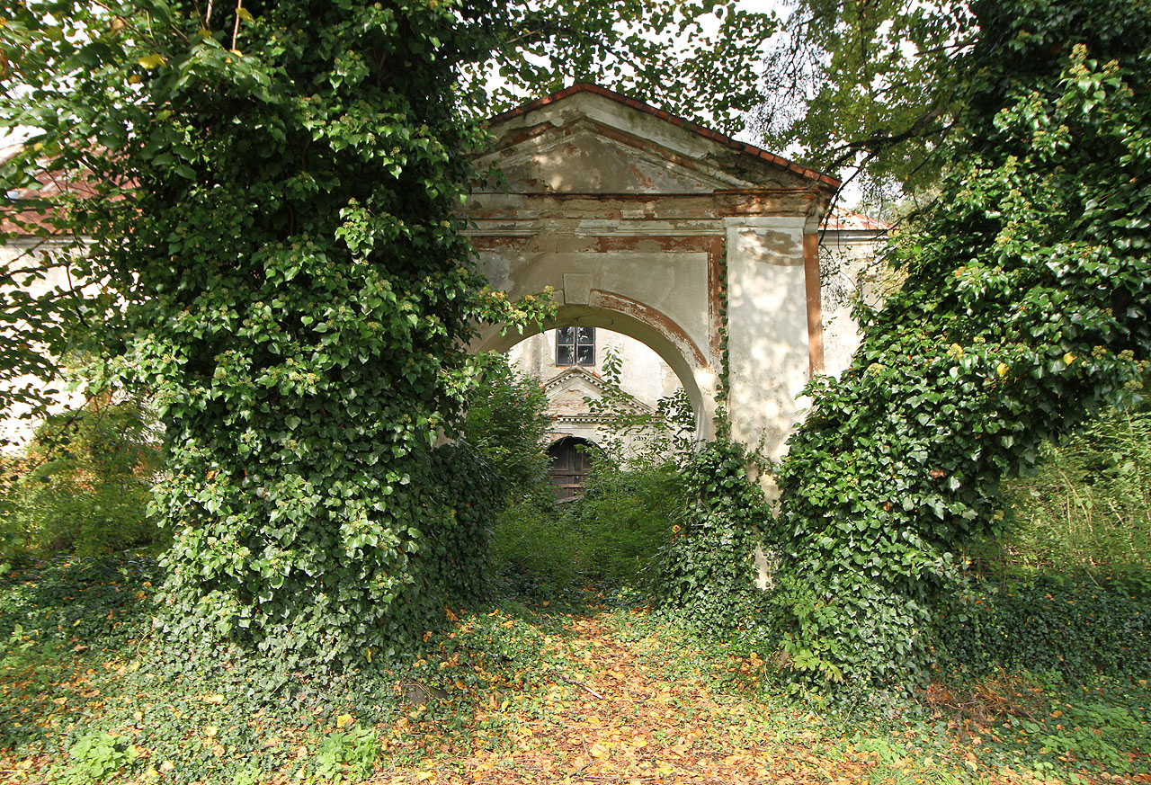 Pohled na bránu ke Starému zámku. Ten vznikl přestavbou středověké tvrze a dodnes je kolem něja patrný zbytek obranného příkopu.