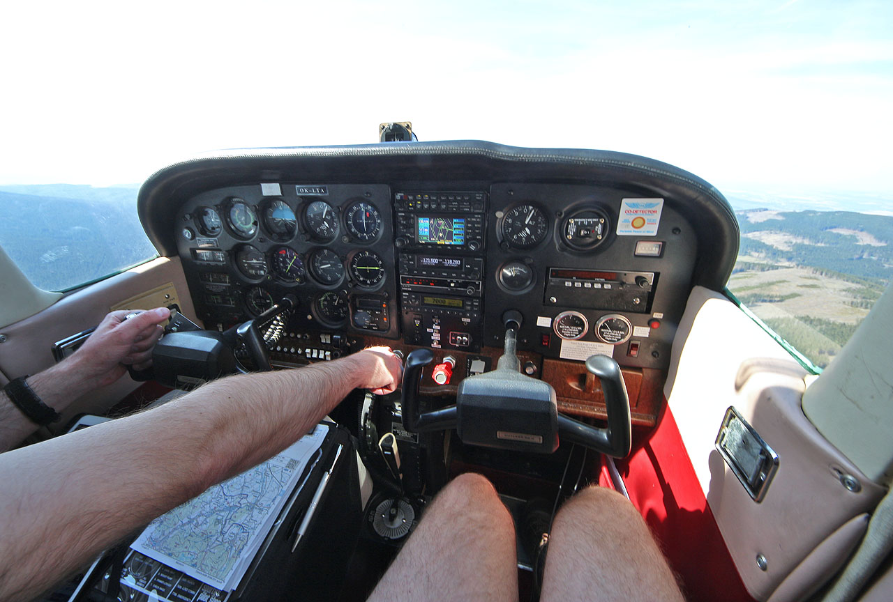 V Cessně 172RG není zvlášť moc místa na nohy. Pilotovat lze navíc z obou předních sedadel a tak si musím dávat pozor, abych nezasahoval do řízení. Dost na tom, že jsem Martinovi několikrát omylem vpadl do komunikace se zemí.