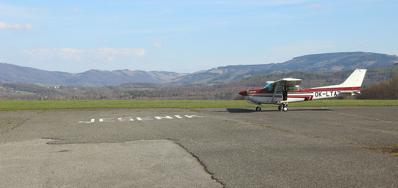 Přistáváme na jediné dráze 05/23 letiště v Mikulovicích, které se někdy též nazývá Jeseník. Dráha je travnatá a před dosednutím jsme věží varováni, abychom se vyhnuli její první třetině, kterou rozryla divoká prasata.