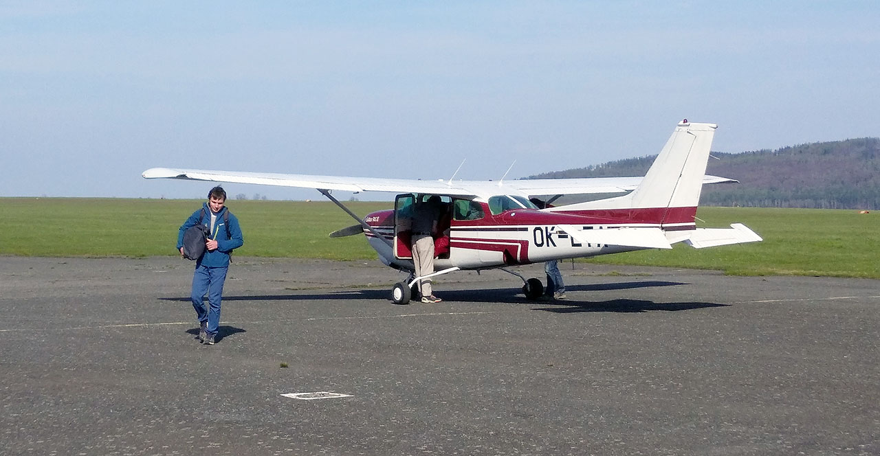 Vystupujeme, z kufru taháme batohy a Martin kontroluje množství paliva. Odkudsi z lesa přichází Kenny, který nás vystřídá a s Martinem bude pokračovat ku Praze. Idylka. Celá cesta nám nezabrala ani hodinu.