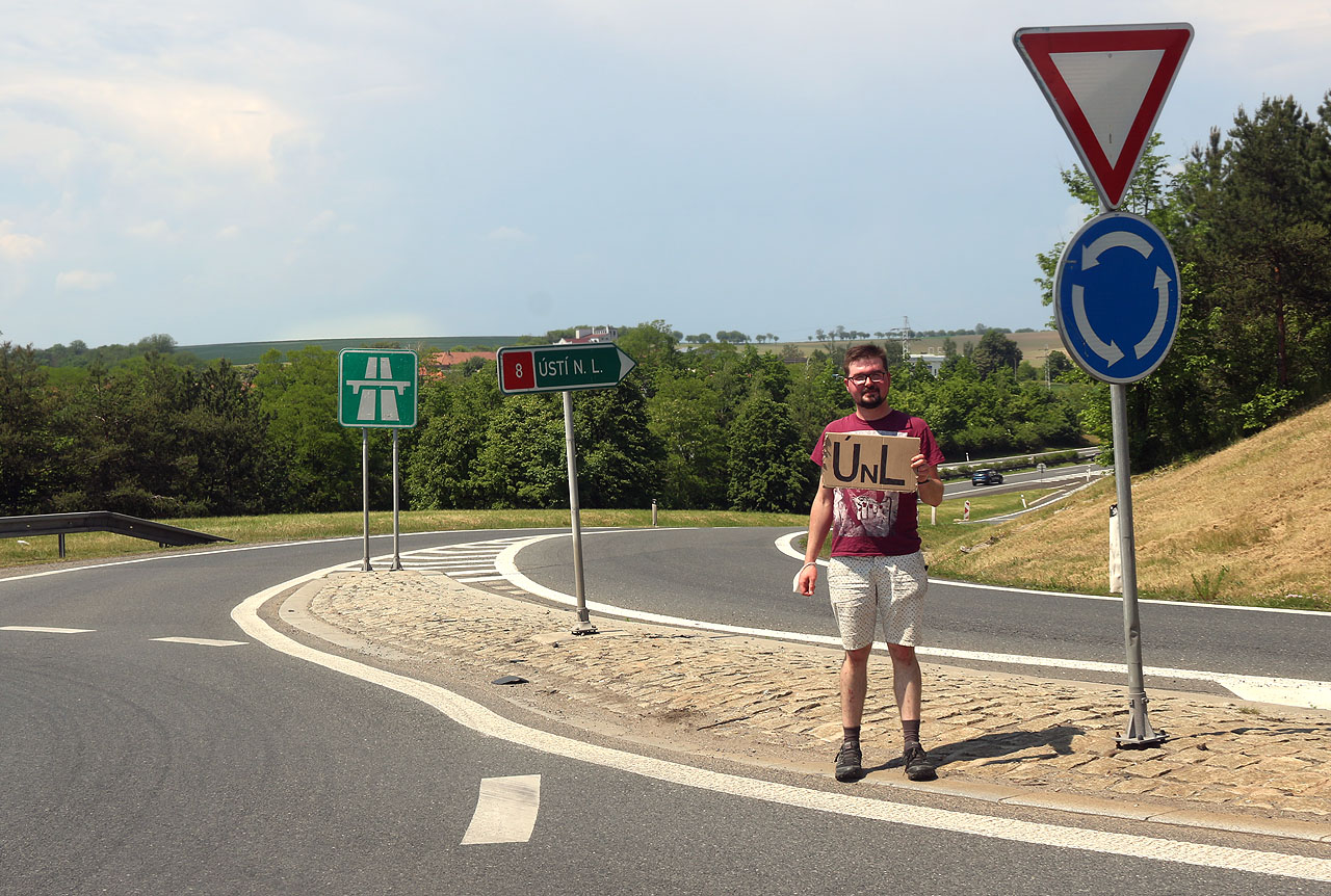 Z Prahy jsme vyjeli díky Honzovu charismatu a ukecávání na benzínce překvapivě rychle, nestrávili jsme tam ani čtvrt hodiny. Poněkud alternativní pár mířící na brigádu někam ke <a href="/Tema/Slaný">Slanému</a> nás ale vyhodil na vyprahlé křižovatce mezi <a href="/Tema/Nová Ves (ORP Kralupy nad Vltavou)">Novou Vsí</a> a Vepřkem u Kralup a tak došlo i na správné dlouhé a úmorné stopování s cedulkou na slunci.