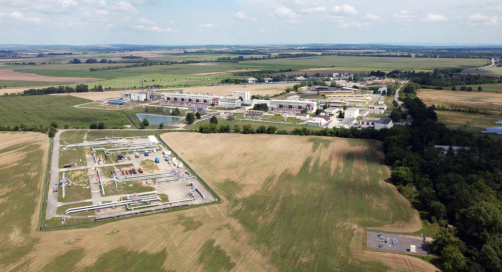 Ponad potrubím jsme dospěli až ke <a href="/Tema/Břeclav">Břeclavi</a>, kde se nachází po proudu plynu první velká kompresní stanice na českém území. Vpravo na kraji fotky se pak ukrývá obří podzemní zásobník plynu Tvrdonice.