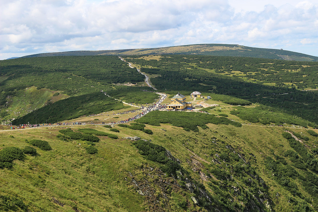 Turistická fronta na polské straně je ještě podstatně horší než na té české. Tady jde člověk opravdu s pohledem upřeným na záda Poláka před sebou a nesmí se zastavit, aby do něj nenarazil Polák za ním. Denně vystoupá na Sněžku tímto způsobem mnoho tisíc lidí.