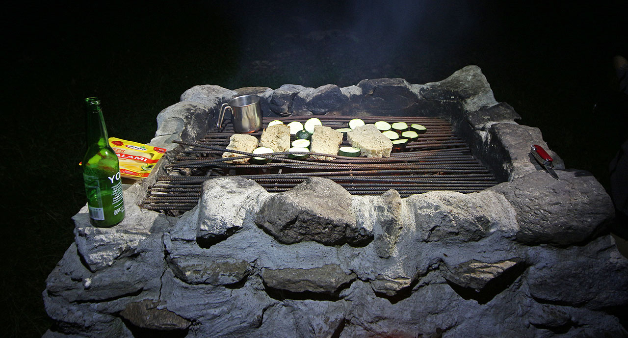 Opečenou cuketu, kus sýra, tvrdý chleba a láhev čajové limonády.