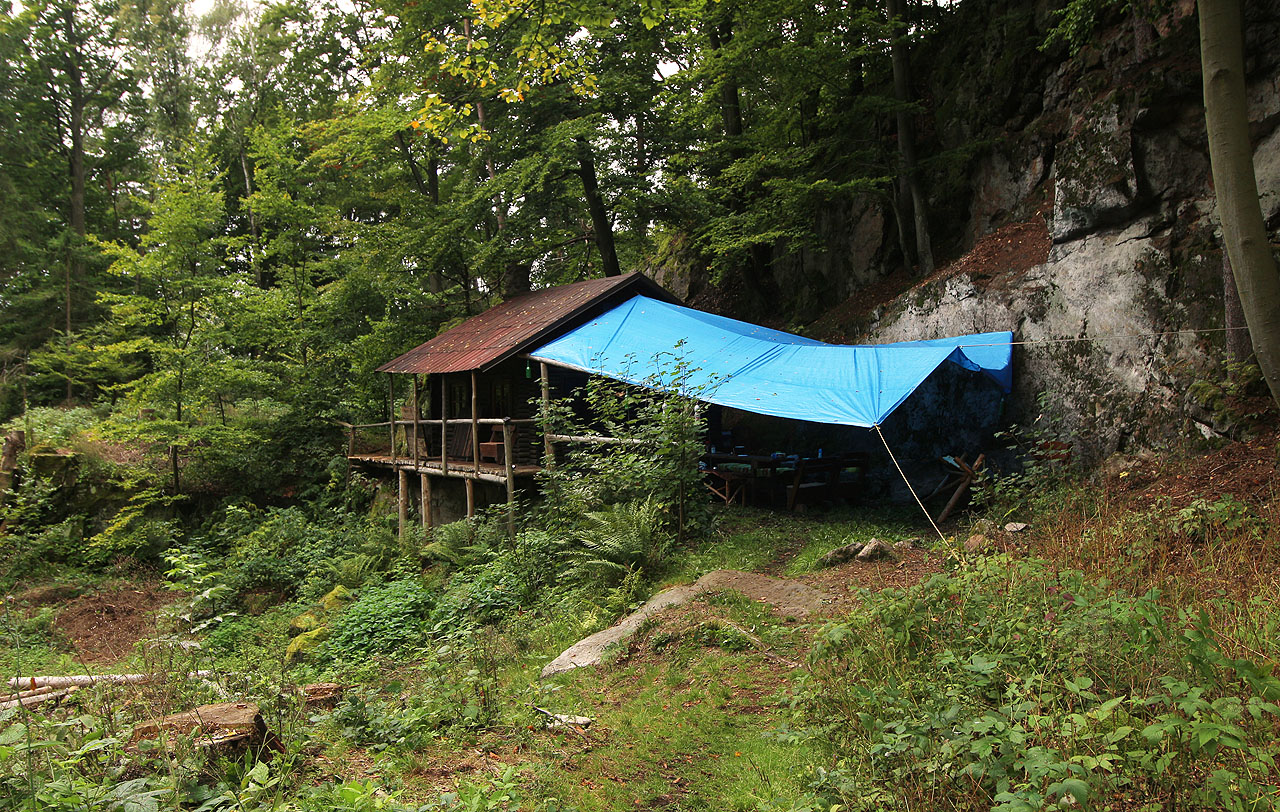 Taky tady se nachází dřevěná chata/srub, nicméně o trošku větší a s ošklivou modrou plachtou vně.