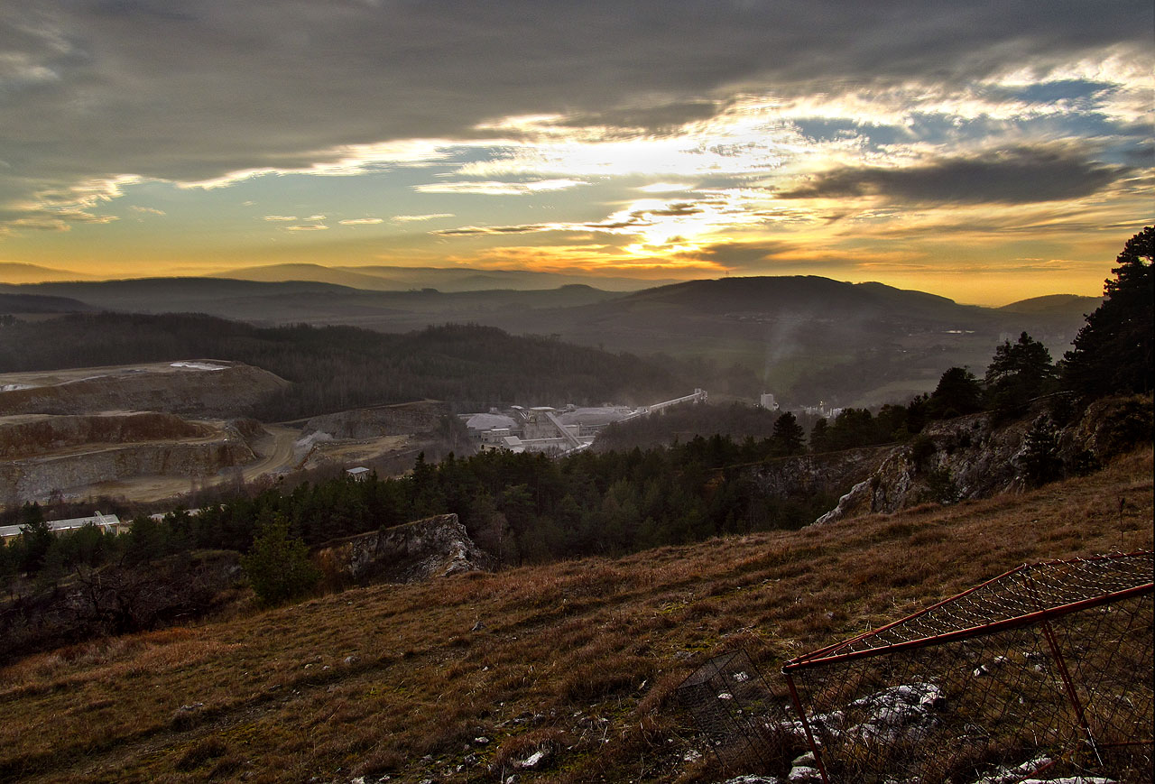 Pohled na Čertovy schody od vstupu do Koněpruských jeskyní, k jejichž objevu v 50. letech 20. století těžba přispěla. Lom ve své spodní části ústí k drtičce a třídírně kamene a vlečkovému nádraží.