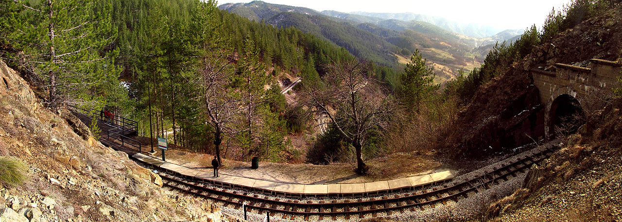 Panorama z nejsložitějšího úseku za tunelem č. 37 u vyhlídkové zastávky Krst. Pod zastávkou je vidět dva jiné oblouky v různých výškových úrovních.