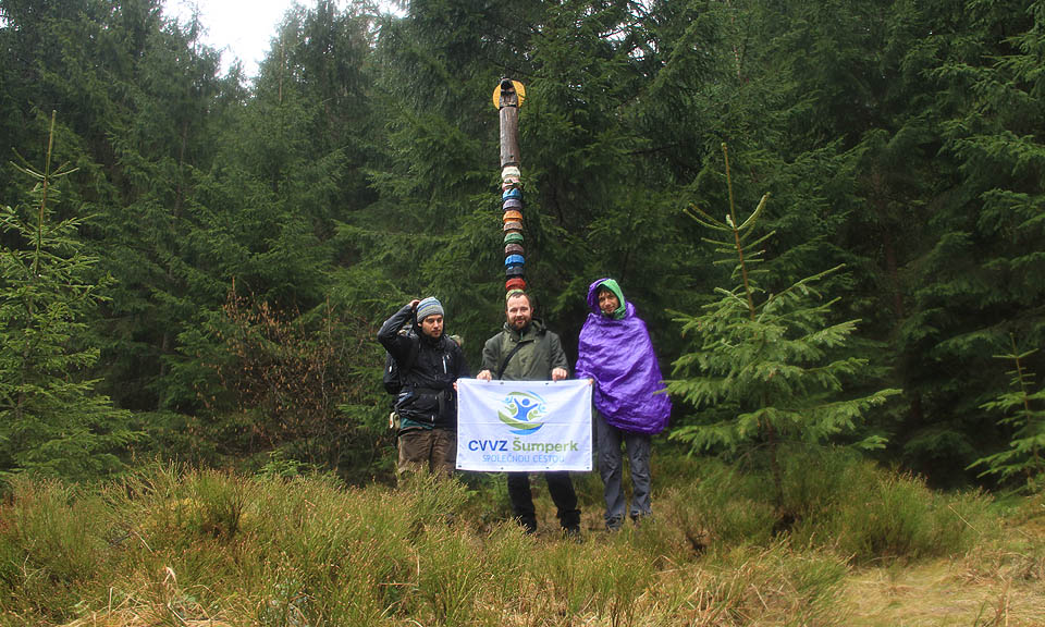 Poslední společná fotka s vlajkou a pod totemem, už zase v dešti.