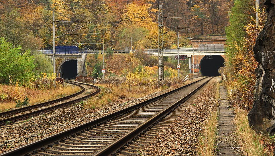 Pohled ze severu od místa oddělení obou kolejí <a href=/Tema/%C5%BDelezni%C4%8Dn%C3%AD%20tra%C5%A5%20Brno%20%E2%80%93%20%C4%8Cesk%C3%A1%20T%C5%99ebov%C3%A1>železniční trati č. 260</a> do nového a starého Novohradského tunelu. Před tunely protéká řeka <a href=/Tema/Svitava>Svitava</a> a za ní na mostě vede silnice II/379 mezi <a href=/Tema/Blansko>Blanskem</a> a <a href=/Tema/Lip%C5%AFvka>Lipůvkou</a>.