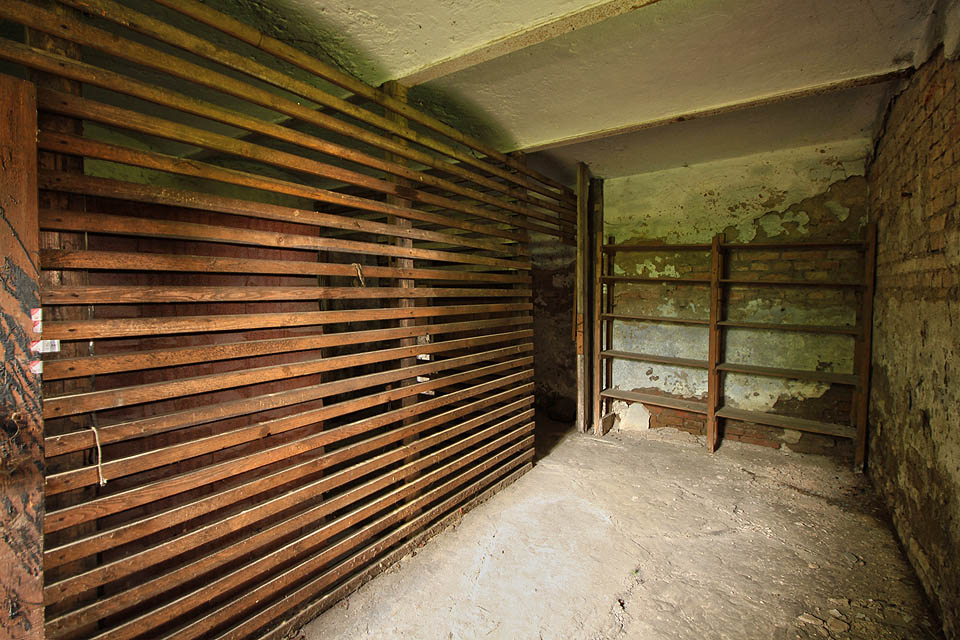 Moderní sklepní kóje z období socializmu kontrastují se stropem z cihelných kleneb vyzdívaných do ocelových nosníků.