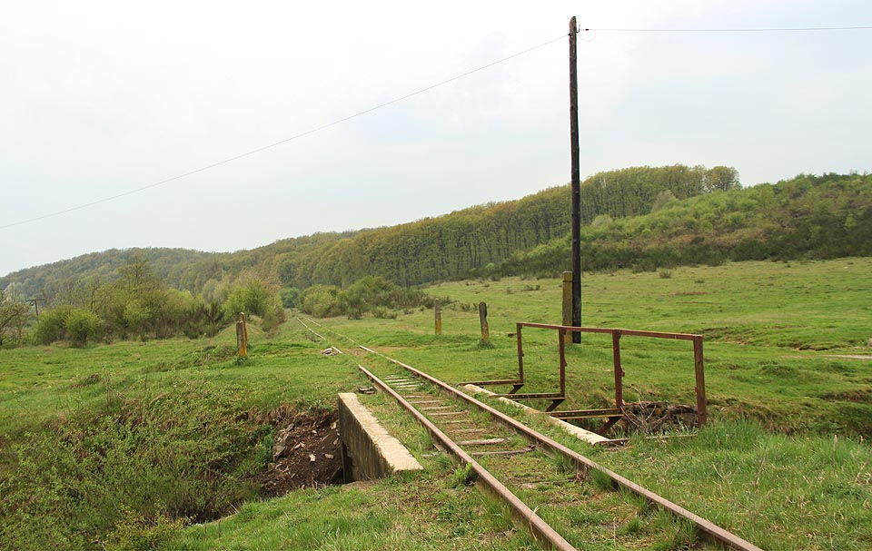 Místo bývalé zastávky З. П. Хмільник, ze které už v roce 2017 nezůstalo zhola nic. Dráha zde prochází absolutní rovinou na pravém břehu řeky Tisy. Mluví se tu výhradně maďarsky, i když ukrajinsky a rusky tu umí skoro každý, a Maďarsko tu krajina dokonale připomíná.