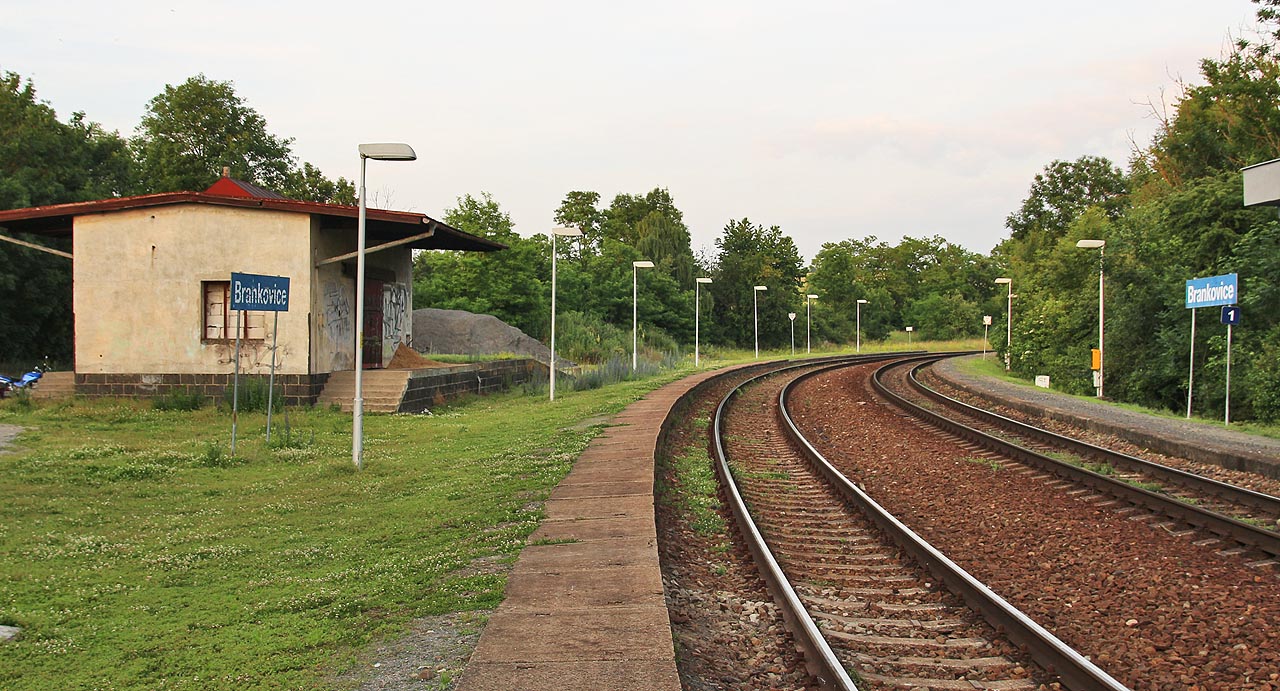 Pohled směr <a href="/Tema/Kyjov (žst)">Kyjov</a> a <a href="/Tema/Veselí nad Moravou (žst)">Veselí nad Moravou</a>. Ke skladišti na levě straně oblouku vedla kdysi manipulační kolej, další se nacházela na hgraně svahu nad obcí vlevo za dlážděnou plochou před skladištěm (vlevo, mimo snímek).