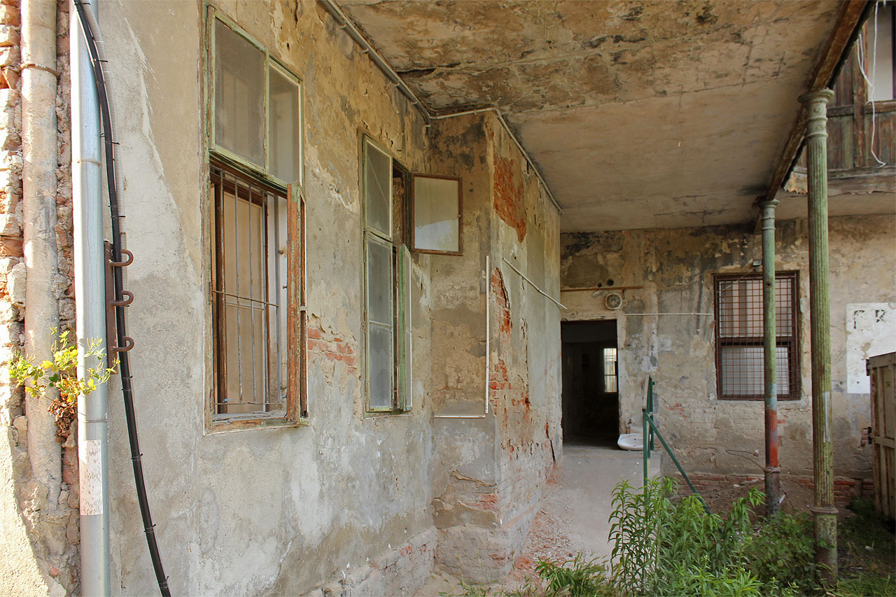 Pohled na nechtěné loubí pod verandou a jeden ze čtyř vstupů, pravděpodobně druhotně vybudovaných v přízemí domu.