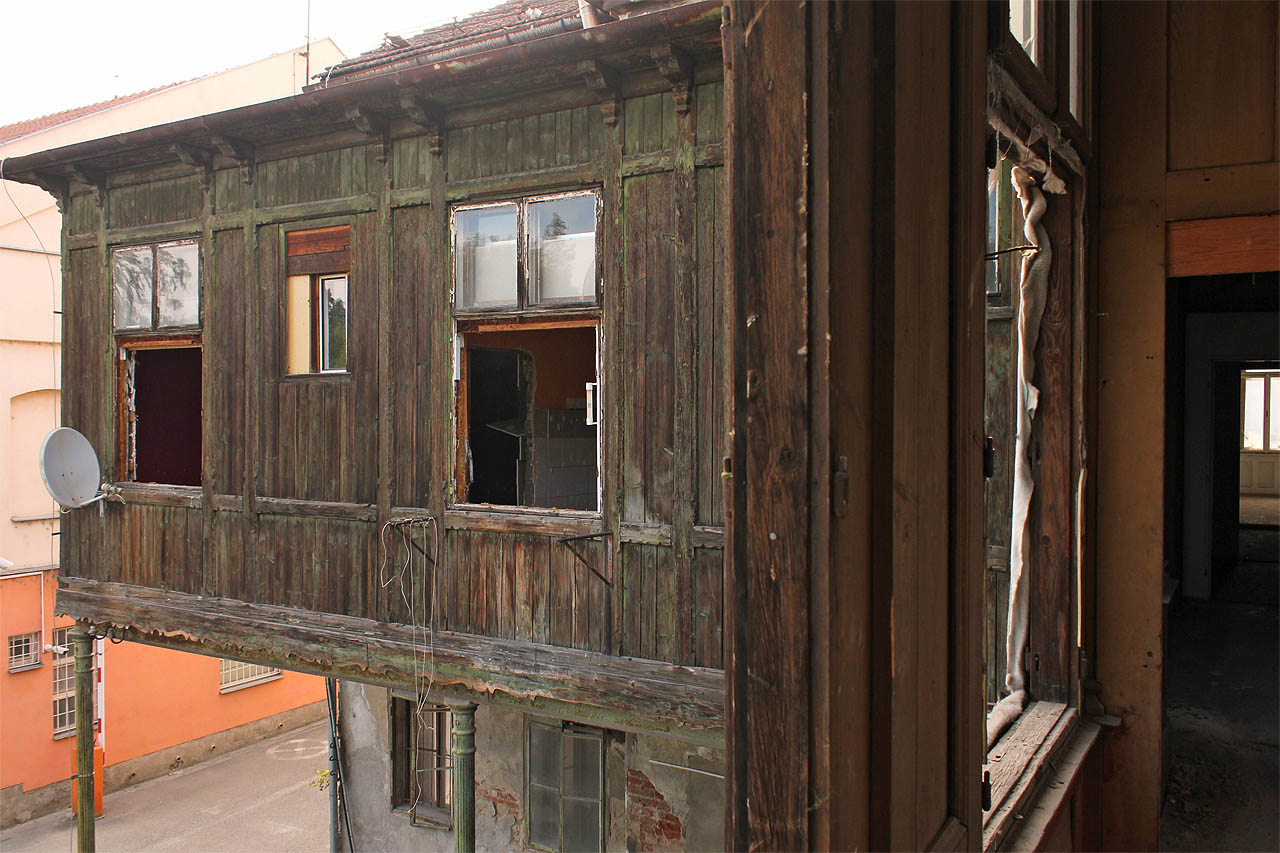 Pohled z verandy na verandu a nezbytná satelitní anténa, nezaměnitelný symbol přelomu 20. a 21. století.