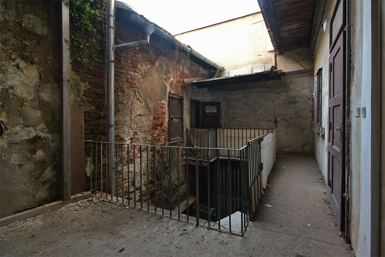 Mohutná zeď o síle takřka jednoho metru uzavírá nad střechou dvorního traktu dům z jediné strany, odkud by do dvora mohlo kdy zasvítit slunce.