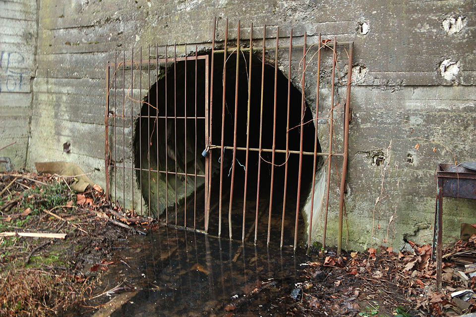 Ocelová mříž kryje vstup do nečekaně dlouhé štoly, která se jako had vine pod celou severní částí městského centra, aby ústila na povrch o 1,2 km dál a o 20 m níž. Pod vodou rezivějící koleje napovídají, že půjde o zajímavé a rozsáhlé dílo.