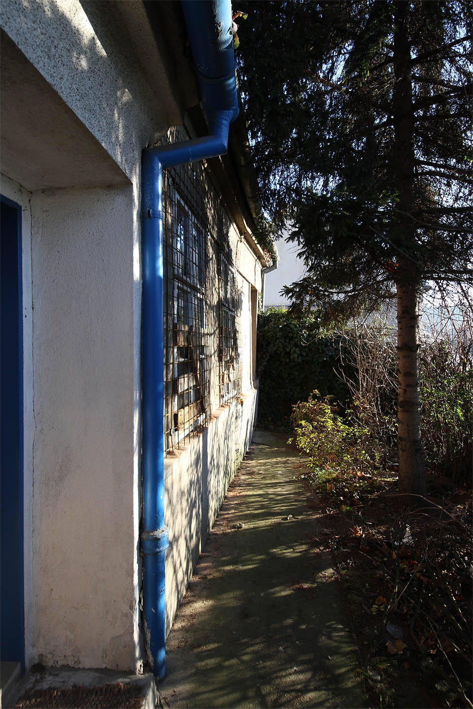 Bližší pohled však odhalil zatlučené dveře a okna přetažená armovacími sítěmi. Tady už zřejmě nikdo nebydlí.