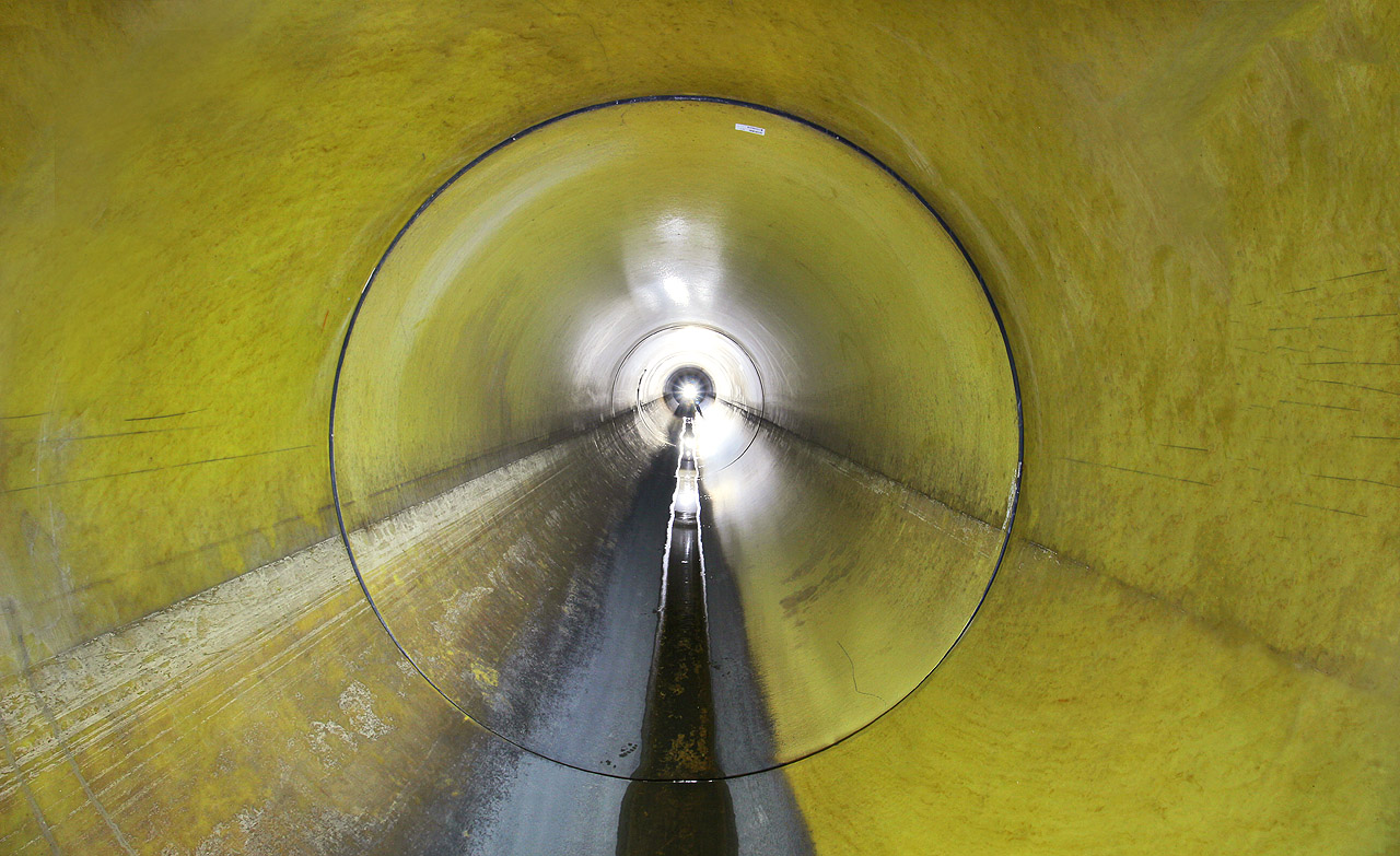 Povzbudivě žlutými rourami lze nachodit několik kilometrů, než se potrubí zúží natolik, že se další plazení stává nepříjemně obtížným.