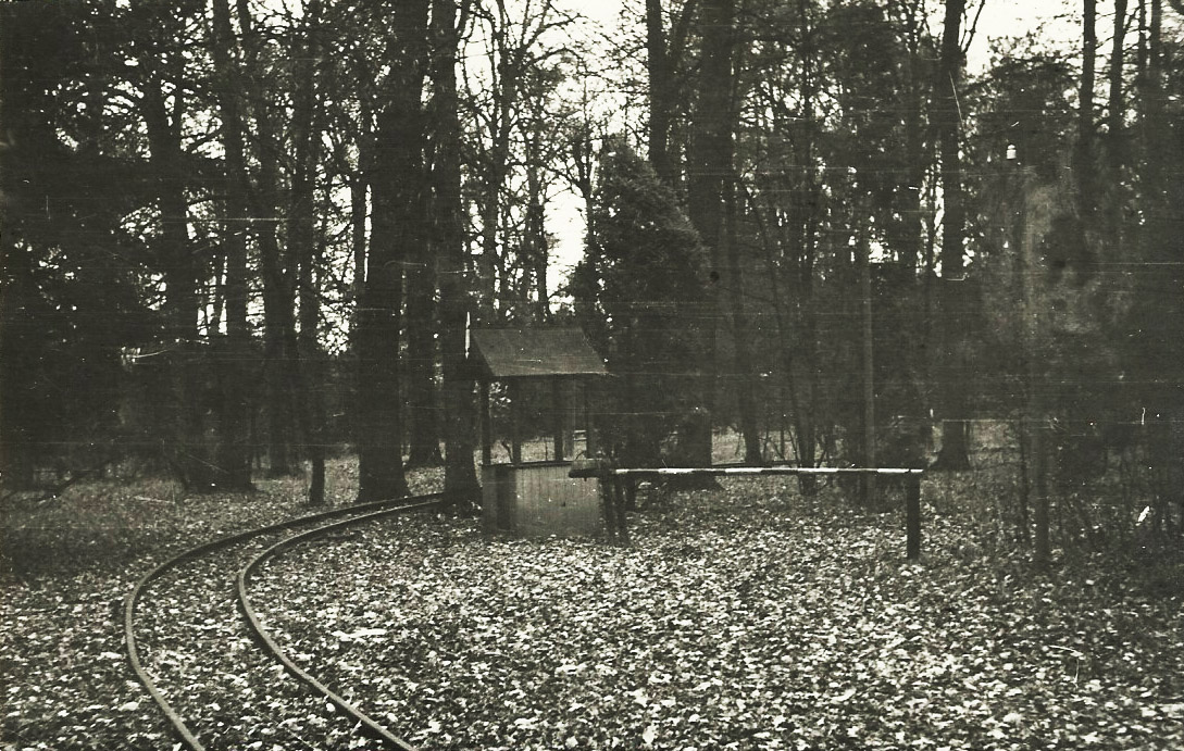 Záběr z trasy dráhy (zřejmě severní cíp parku Michalov) - stanoviště závoráře a ručně ovládané závory. Ze snímku je dobře patrné, že rozchod dráhy byl víc než obvykle uváděných 600 mm. <br>Datum snímku je pouze přibližné, autorem je Vladimír Mokošín.