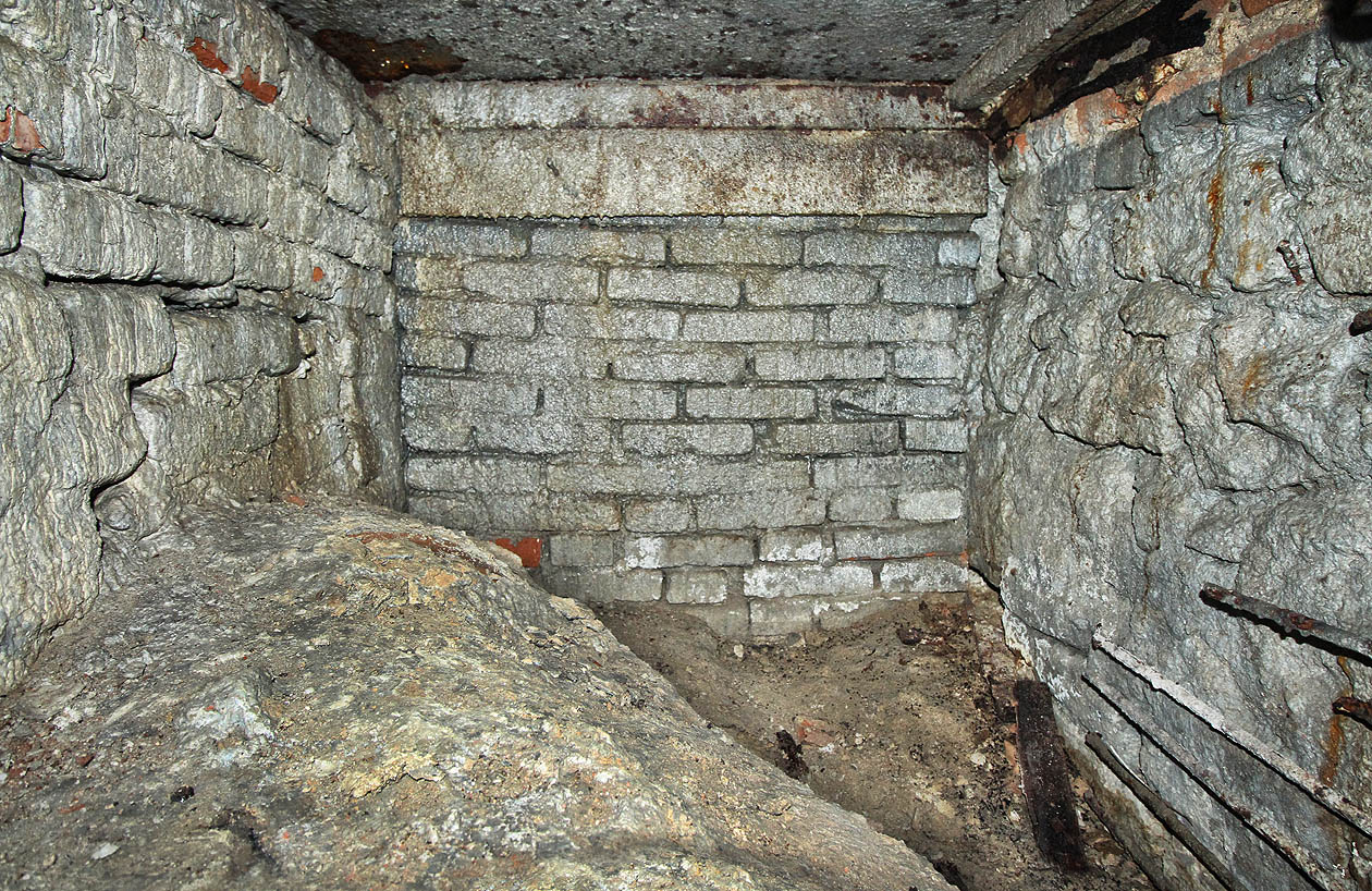 Chodba končí zazdívkou zjevně nebarokní (jemně svisle pruhované cihly odpovídají 80. až 90. létům 20. století). Strop kryje rezivějící ocelová deska zřejmě převrstvená opět betonovou deskou zhruba v úrovni podlahy vyššího patra klášterních sklepů.