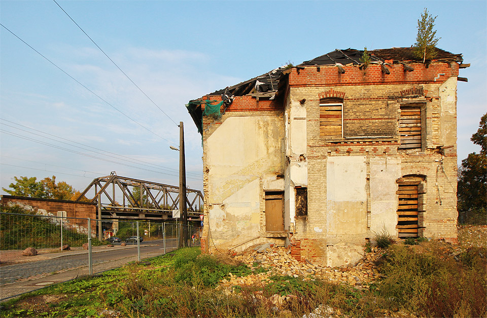 Pohled od západu ve slunce západu. Rozervaná zeď vypovídá o místu, kde na východní křídlo budovy navazovalo větší křídlo západní.