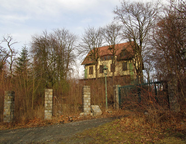 Přístupová cesta vede z malého sedla na Pisárecké ulici přes masivní ocelovou bránu.