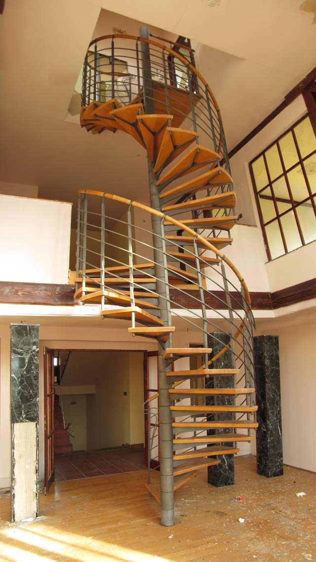 Nově vybudované schodiště přes tři poschodí s luxusním zábradlím vyloženým kůží.