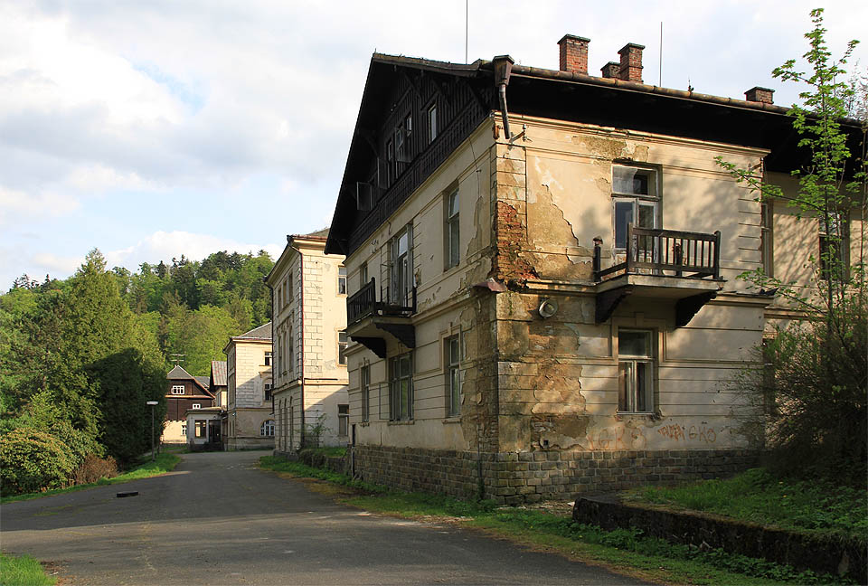 Hlavní budova v pozadí s později přistavěnou správní budovou. Zde bylo rušno 150 let. Dnes tu raší mech.