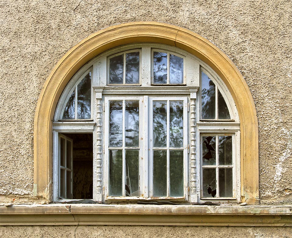 Dekorativní půlkruhová okna hlavní budovy nejsou ani příliš zničená.