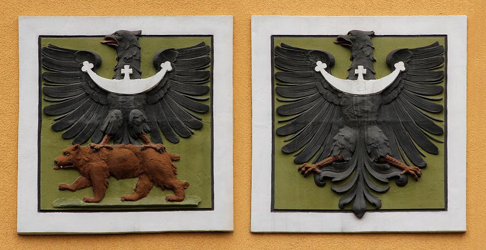Dvojice erbů na fasádě výpravní budovy připomíná symboliku Slezska (černá orlice na zlatém poli vpravo) a znak města <a href=/Tema/Jesen%C3%ADk>Jeseníka</a> (poněkud amputovaná černá orlice jedoucí na medvědu).