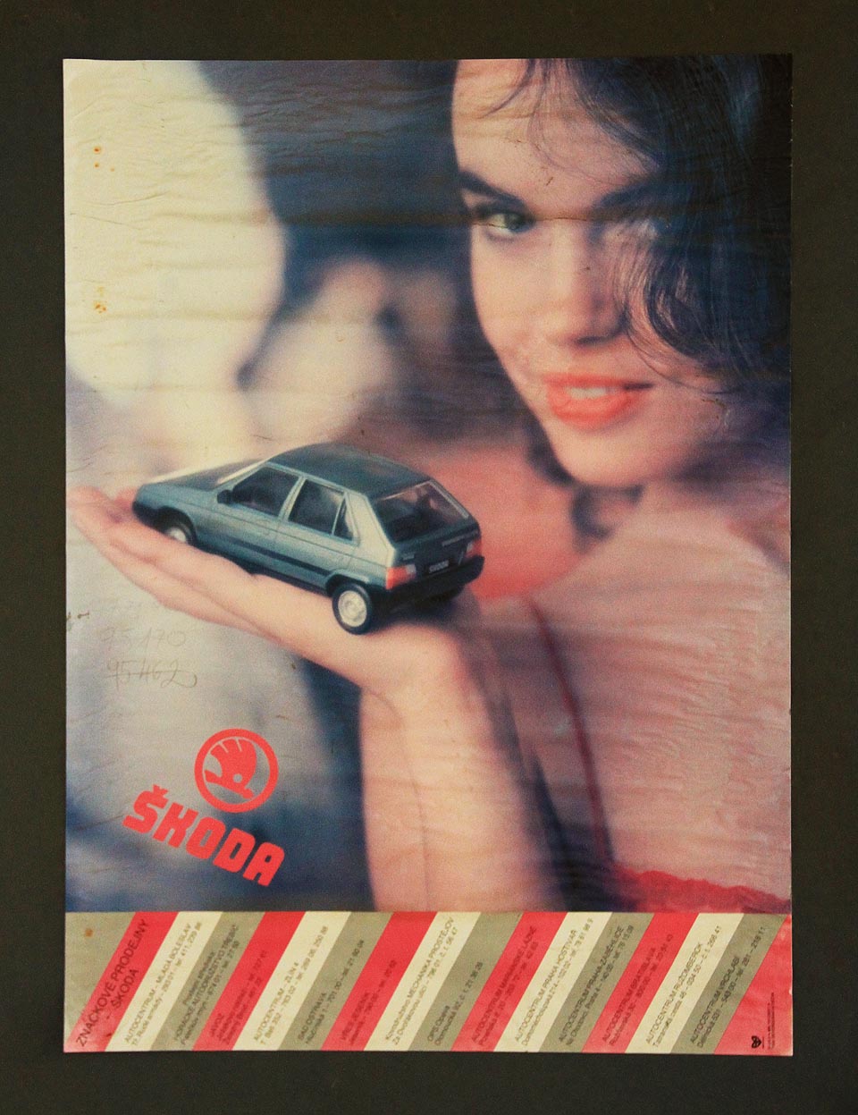 Mírně lascivní slečna láká zaměstnance dřevařských závodů ke koupi moderního vozu Škoda Favorit už skoro třicet let. Favority pomalu mizí z českých silnic, ale úsměv na plakátu je pořád skoro stejně zářivý.