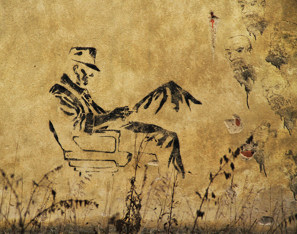 Těžko říct, čím listuje muž, kterého tu v blíže neurčené době kdosi nakreslil na zeď pod hejno usekaných hlav. Připomíná snad jednoho z Italů či Dalmatinců, kteří tu pracovali za 1. světové války?