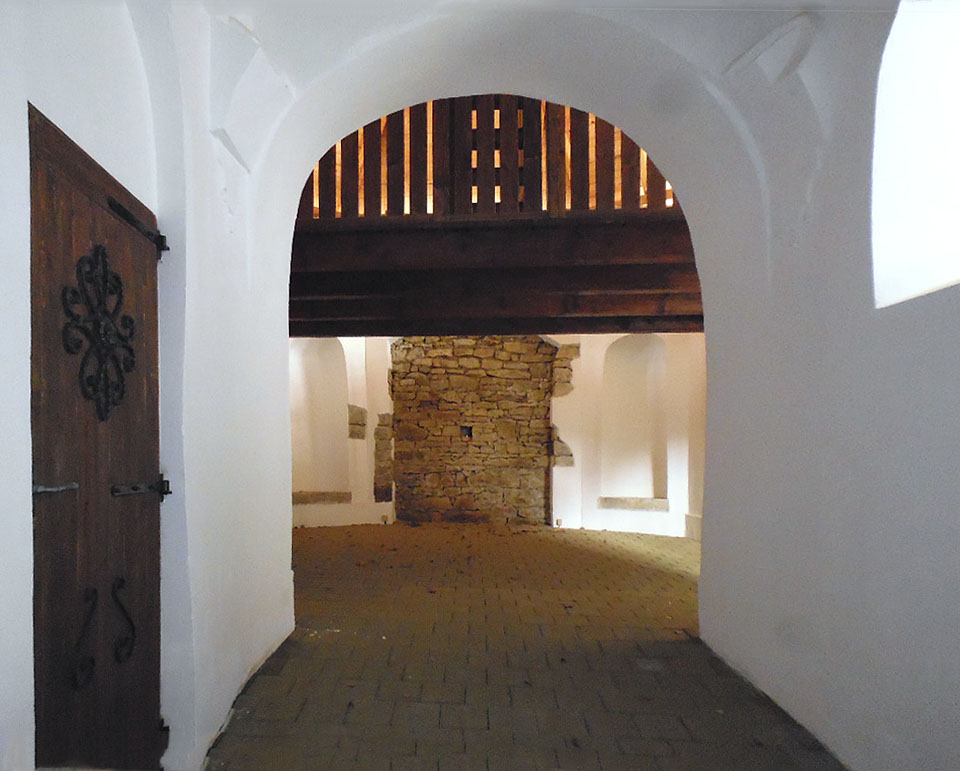 Pohled otvorem ve vstupních dveřích do opravené kaple, která je však pustější než dřív.