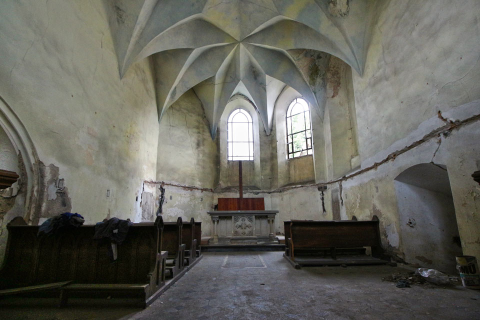 Pohled do kapelní lodi od hlavního vstupu. Vpravo je dobře patrný druhotně proražený průchod do sakristie v jižním křídle špitálu.