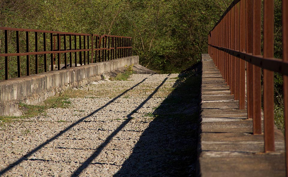 Jako by středem viaduktu vedla kolej, která měla kdysi spojit <a href="/Tema/Revúcka Lehota (žzast)">Revúcku Lehotu</a> a <a href="/Tema/Slavošovce (žst)">Slavošovce</a>.