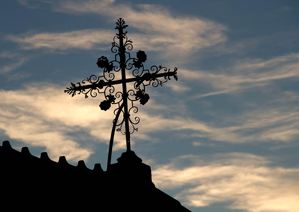 Přichází čas nešpor. Silueta svatého kříže se pomalu noří do tmy.