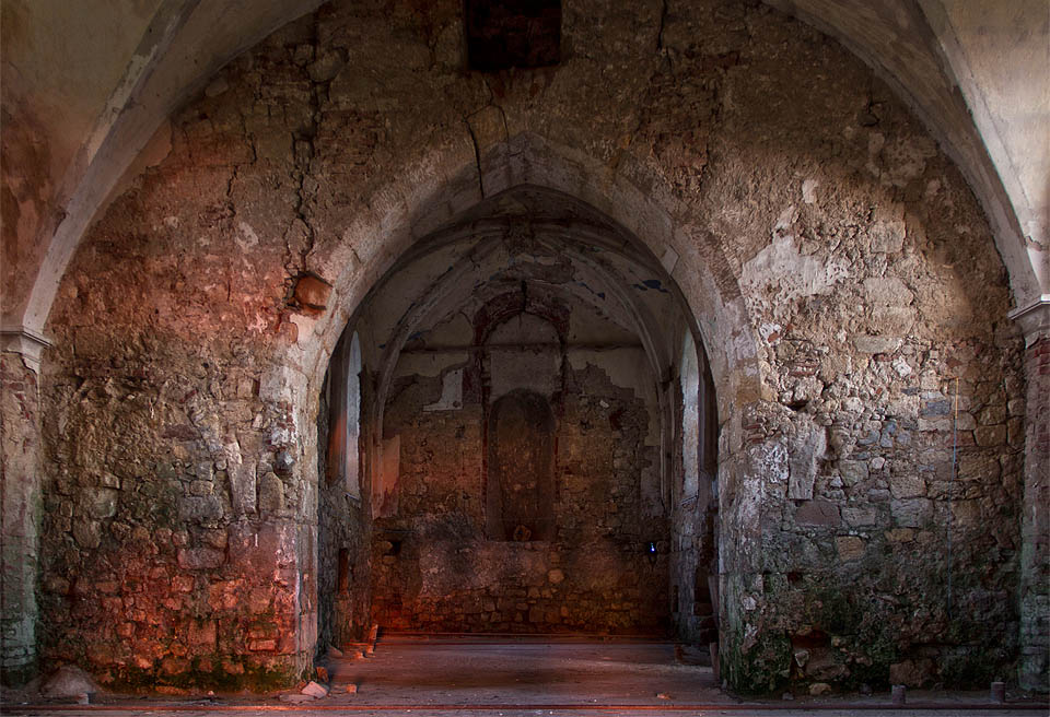 Kamenná zeď oddělující hlavní prostor kostela od skromného presbytáře v paprscích zapadajícího slunce přímo dýchá historií.