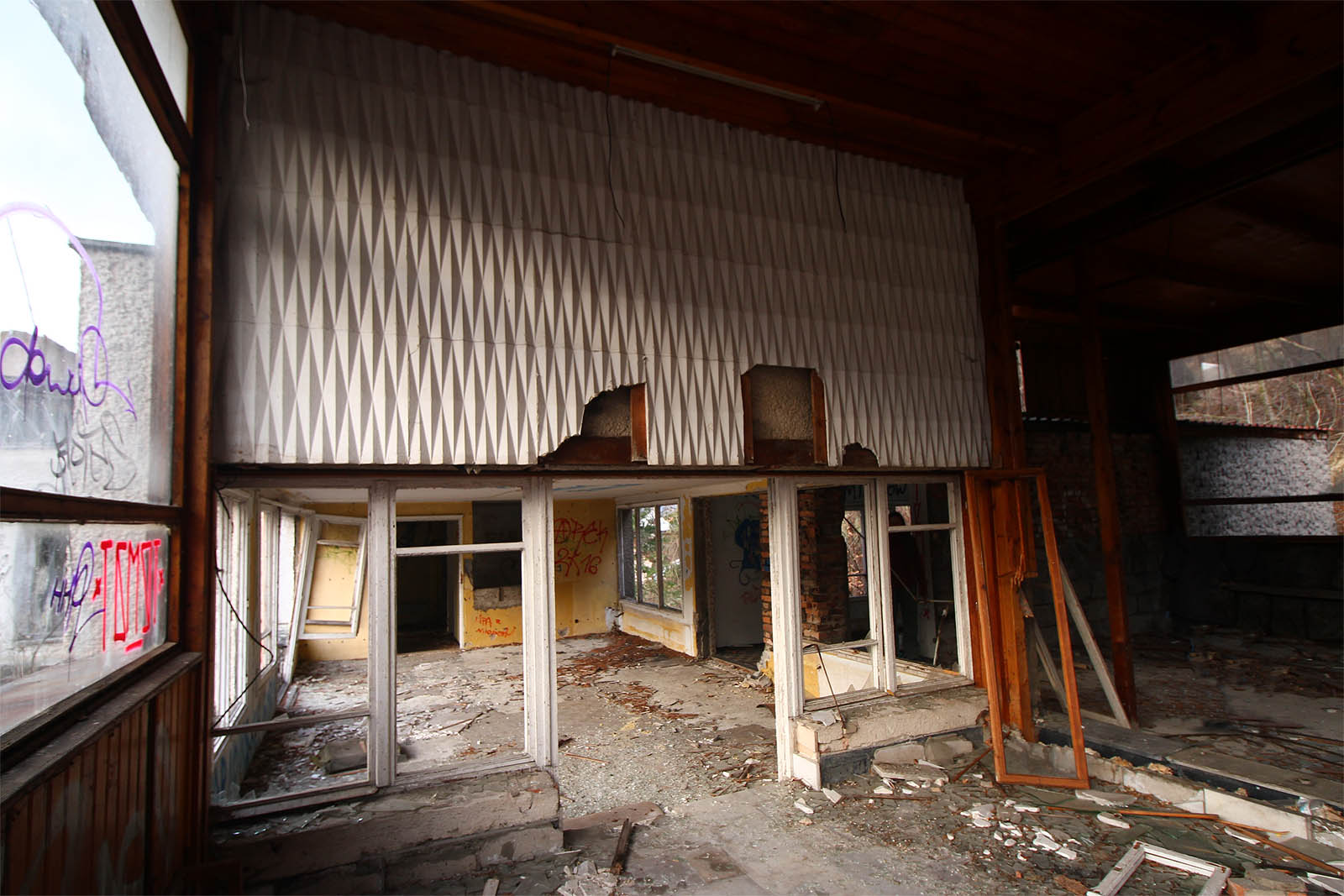 Reliéfní vzory na stěně nad dveřmi poněkud připomínají stropní panely na <a href="/Tema/Havířov (žst)">nádraží v Havířově</a>.