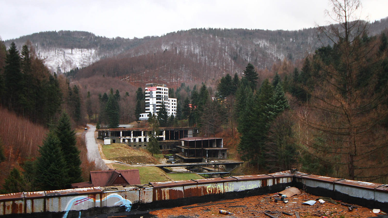 Celkový pohled na Kozubnik na sklonku roku 2016. V pozadí běloskvoucí nová fasáda hotelového domu Kiczora, který zřejmě v roce 2017 již přijme první nové návštěvníky, pod ním hlavní budova s bazény a sportovišti, snížená po sanaci o dvě patra (včetně restaurace), vpravo menší budova s ubytováním, naproti travnatá plocha po zbouraných budovách se salóny a bary. Další objekty se nachází nad Kiczorou v lese i vpravo za hranou ploché střechy.