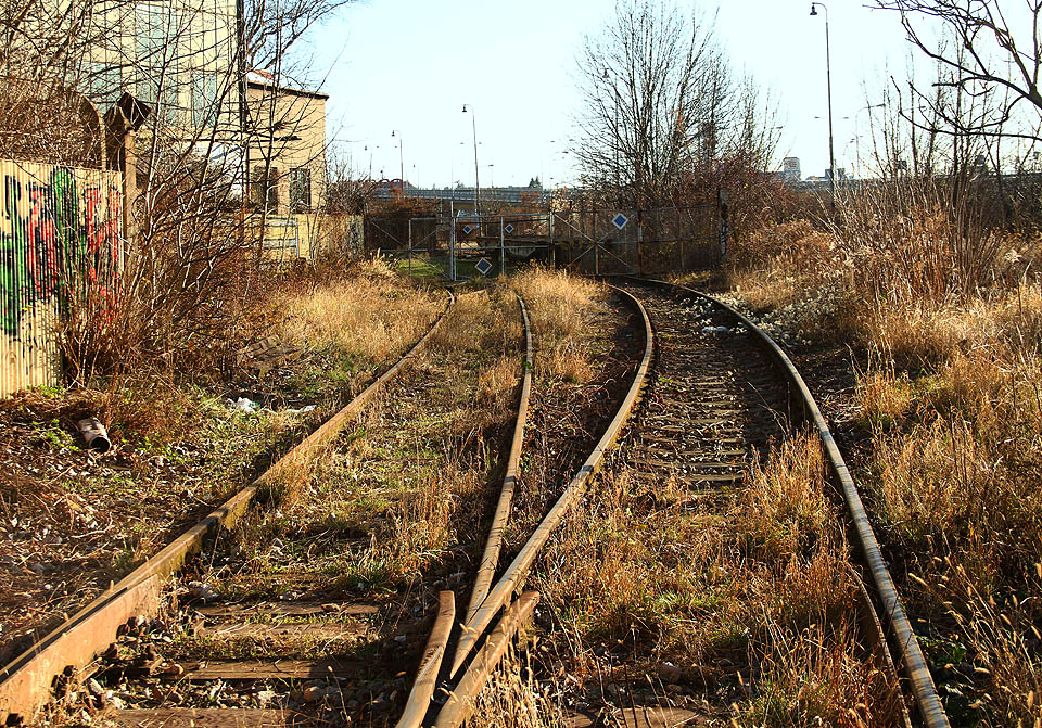 Další vlečková brána je zvláštní hned z několika důvodů - jednak koleje vchází do areálu, aby ho hned po pár desítkách metrů obdobnou branou zase opustily, druhak se přímo pod branou nachází méně typické kolejové křížení.