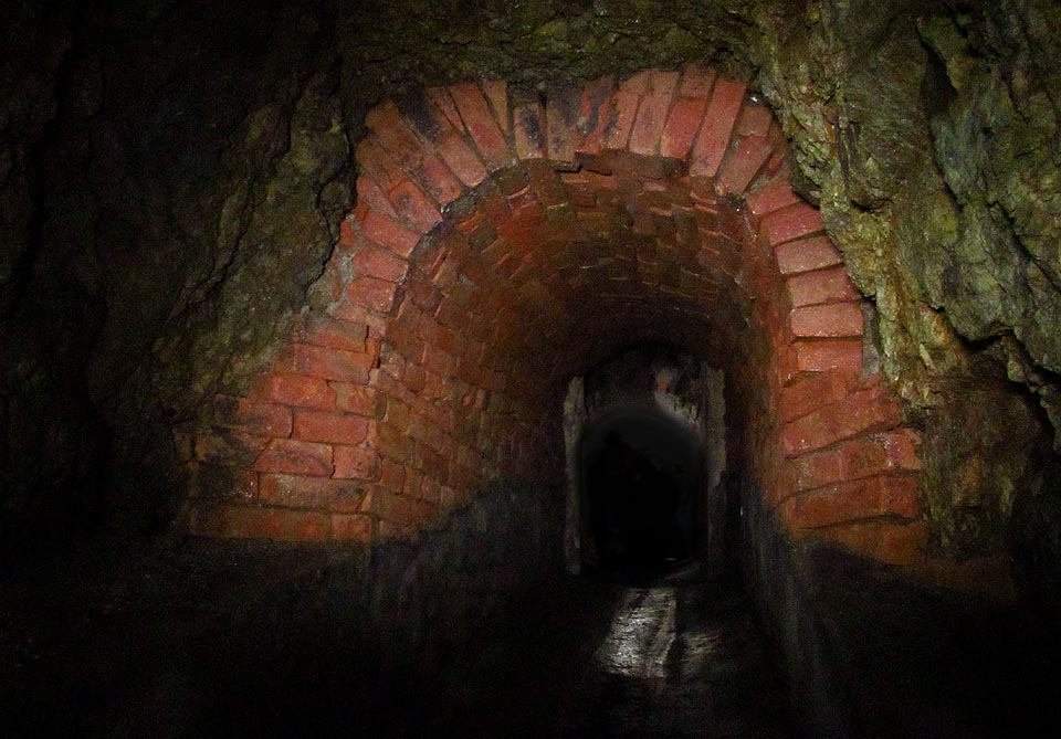 Pár metrů za svým (dnes neprůchozím) začátkem prochází pod hradbami Špilberku.