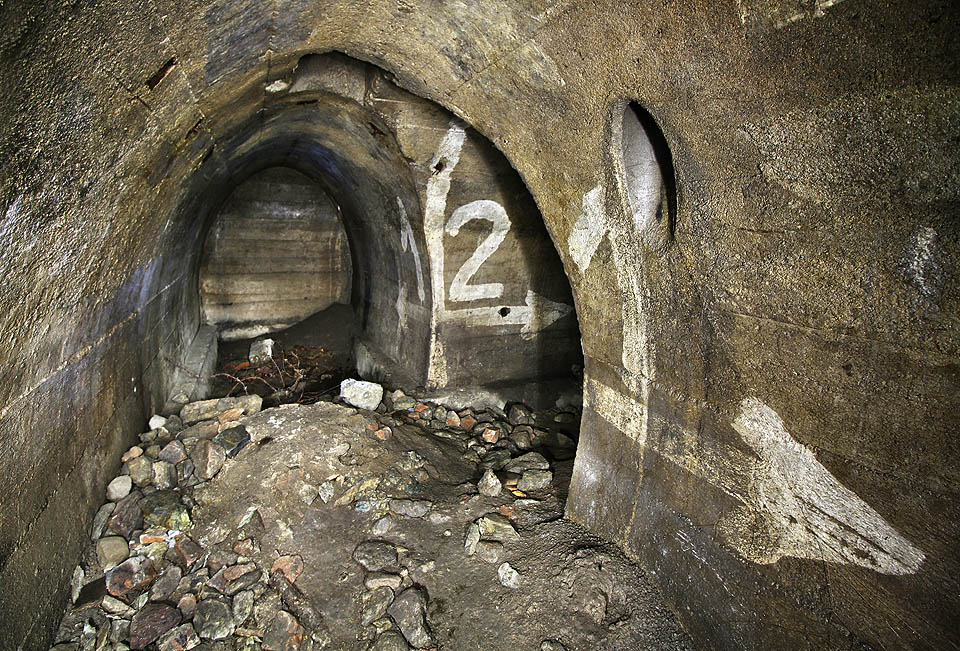 Na jediném místě v krytu se zachovaly nepřehlédnutelné pozůstatky číslování jednotlivých úseků. Čí ruka asi uprostřed válečné vřavy malovala obří číslice na stěnu?