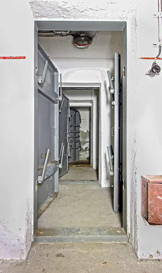 Pohled na trojici pancéřových dveří na západní straně krytu. Světlo zde stále funguje.