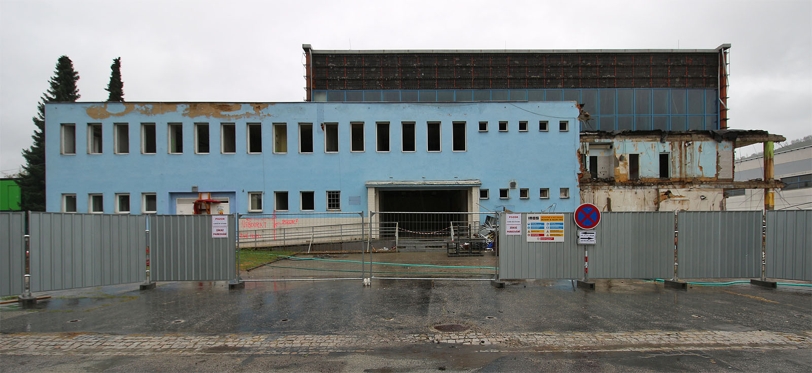 Původní hlavní vstup do budovy z Mlýnské ulice. Jedním z důvodů pro rozhodnutí o demolici a výstavbě nového krytého bazénu byla jeho „bariérovost“, kdy bylo od vchodu nutné jít k bazénu do patra po úzkých schodech. Na druhou stranu tak byl bazén dobře chráněn před případnou povodní a zaplavením vodou ze Svitavy tekoucí v těsném sousedství.