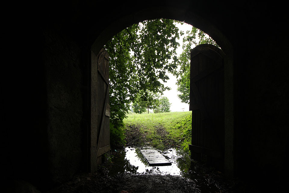 Ve vlhčím období se před vraty tvoří kaluže vody, snad částečně vyvěrající z podzemního pramene obnaženého při hloubení sklepa.