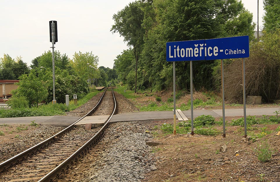Pohled na zastávku od severu, přibližně z místa, kde křížila dráhu úzkokolejka vedoucí k <a href=/Tema/Podzemn%C3%AD%20tov%C3%A1rna%20Richard>podzemní továrně Richard</a>. Na ceduli je název uveden v souladu s pravidly pro názvy zastávek a stanic, ale v rozporu s oficiálními údaji.