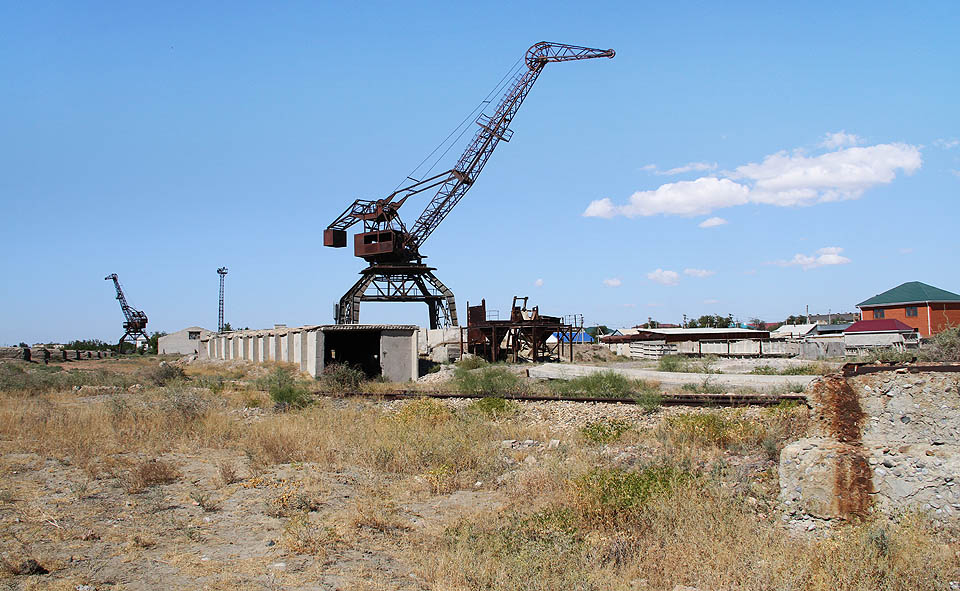 Přístavní jeřáby připomínají kostry dávno zhynulých dinosaurů. V agresivním slaném větru se postupně spokojeně rozpadávají.